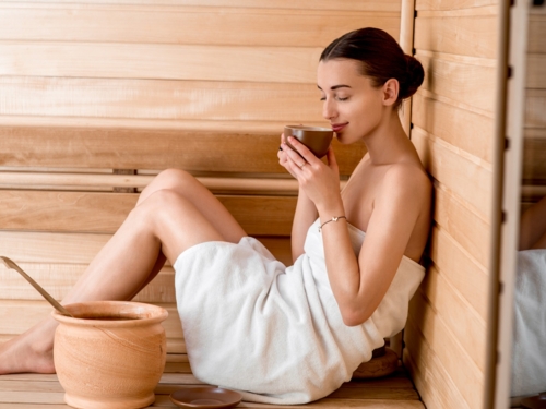 wellness_spa_sauna_relax_woman_towel_drinking_bucket_sh_249345706